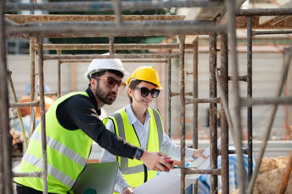 Engineer and architect double-checking plans and processes on the construction site.