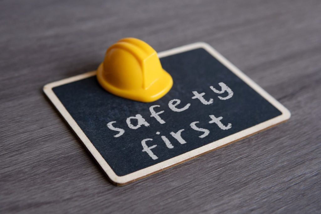 Yellow hard hat resting on a chalkboard, symbolizing safety measures and construction planning.