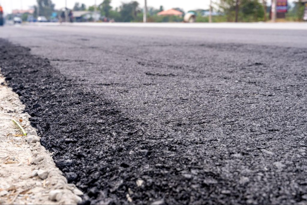 Asphalt next to a sidewalk. 