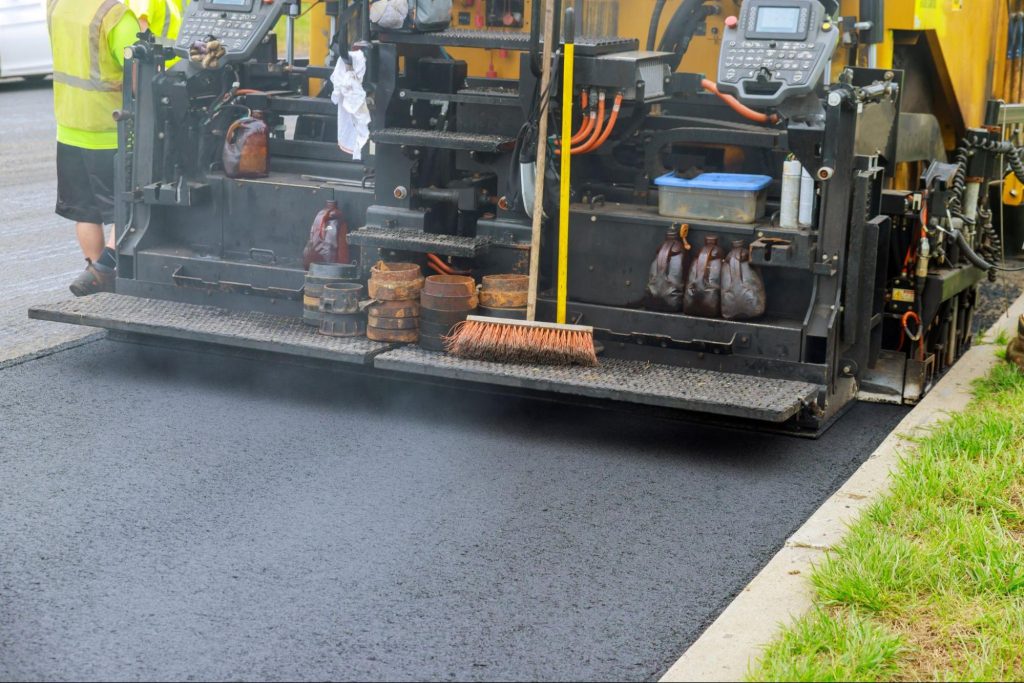 Workers on an asphalt paver. 