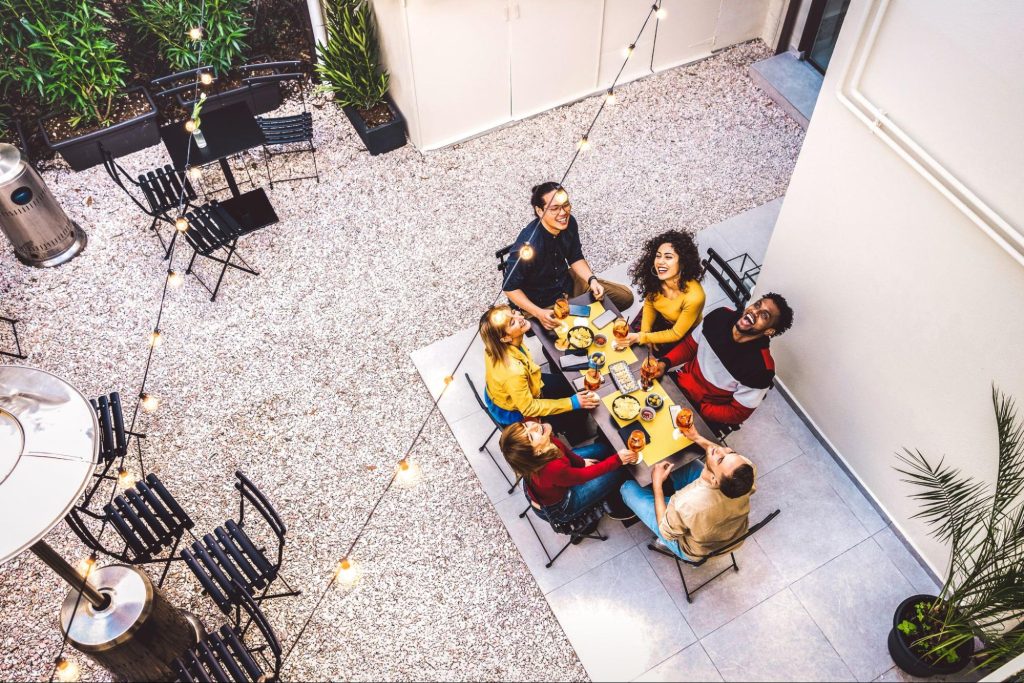 A group of friends eating on their concrete patio.