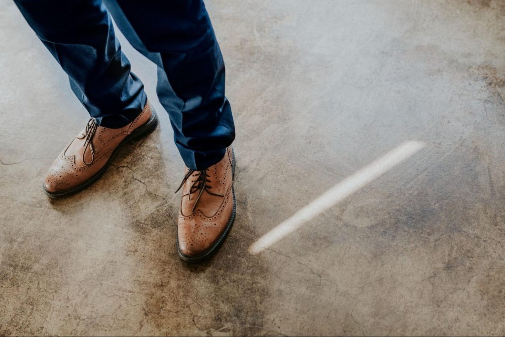 Man standing on stained concrete flooring. 